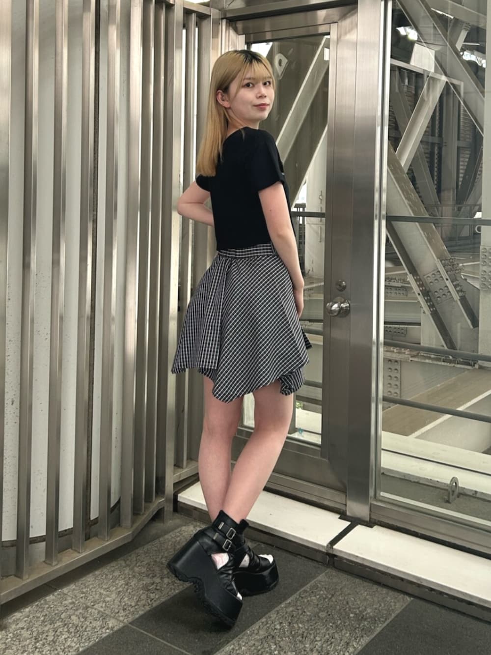 ブラック系のブーツ、ブルー系のスカート、ブラック系のTシャツ/カットソーを着用したレディースの夏コーディネートの3枚目の写真