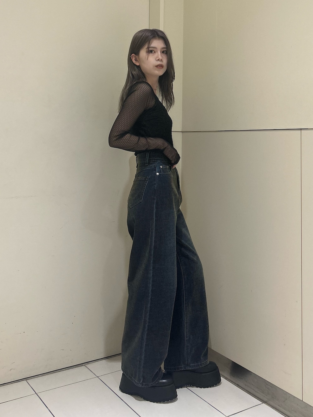 グリーン系のデニムパンツ、ブラック系のTシャツ/カットソー、ブラック系のブーツを着用したレディースの秋コーディネートの2枚目の写真