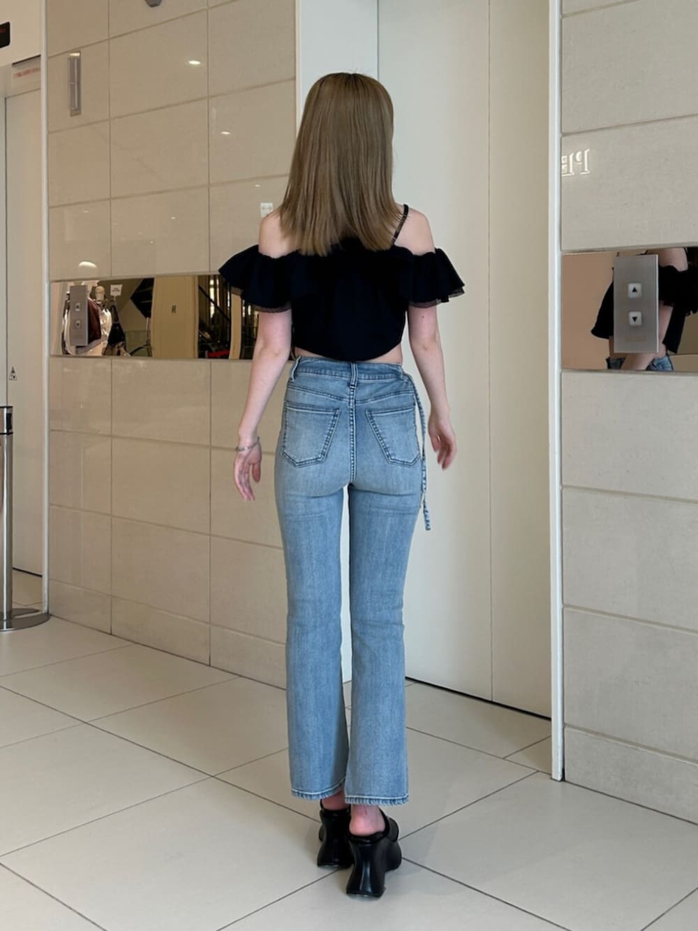ブルー系のデニムパンツ、ブラック系のシャツ/ブラウス、ブラック系のサンダルを着用したレディースの夏コーディネートの3枚目の写真