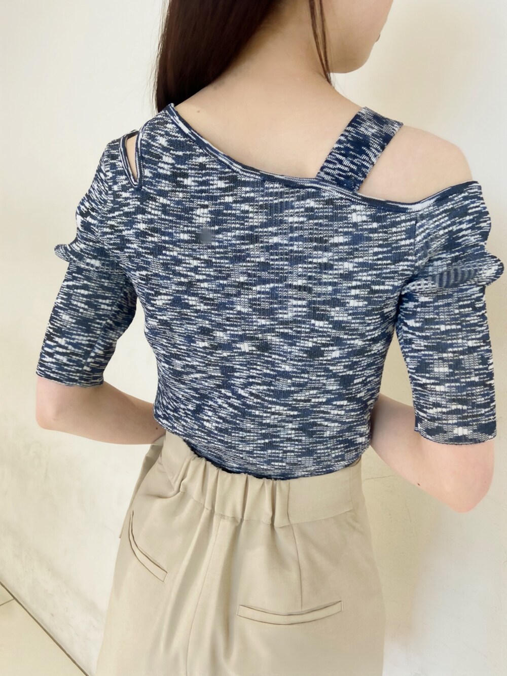 ベージュ系のスラックス、ブルー系のニット/セーター、ホワイト系のサンダルを着用したレディースの春コーディネートの5枚目の写真