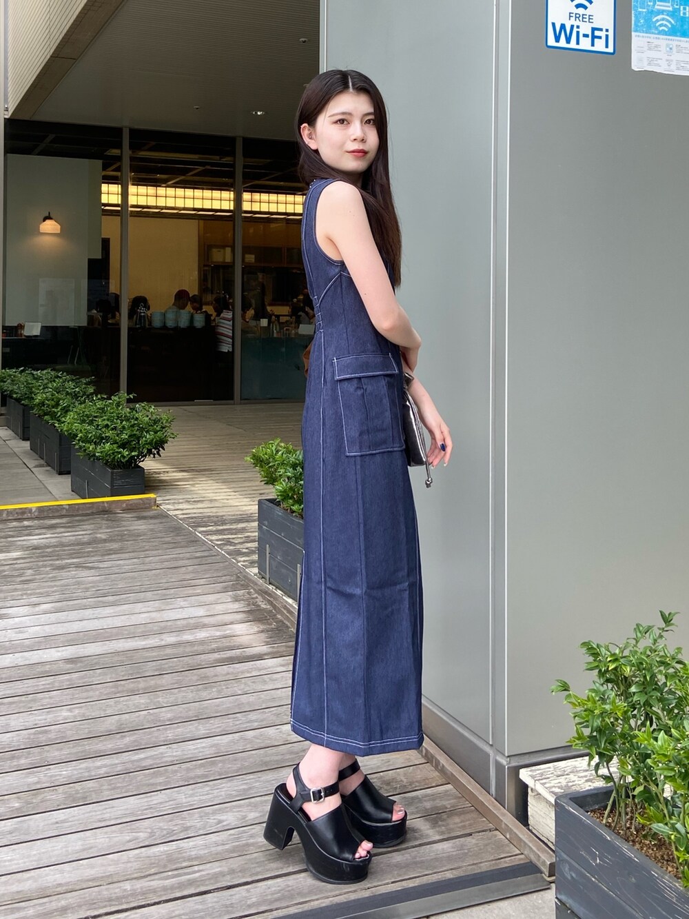 ブルー系のワンピースを着用したレディースの春コーディネートの2枚目の写真