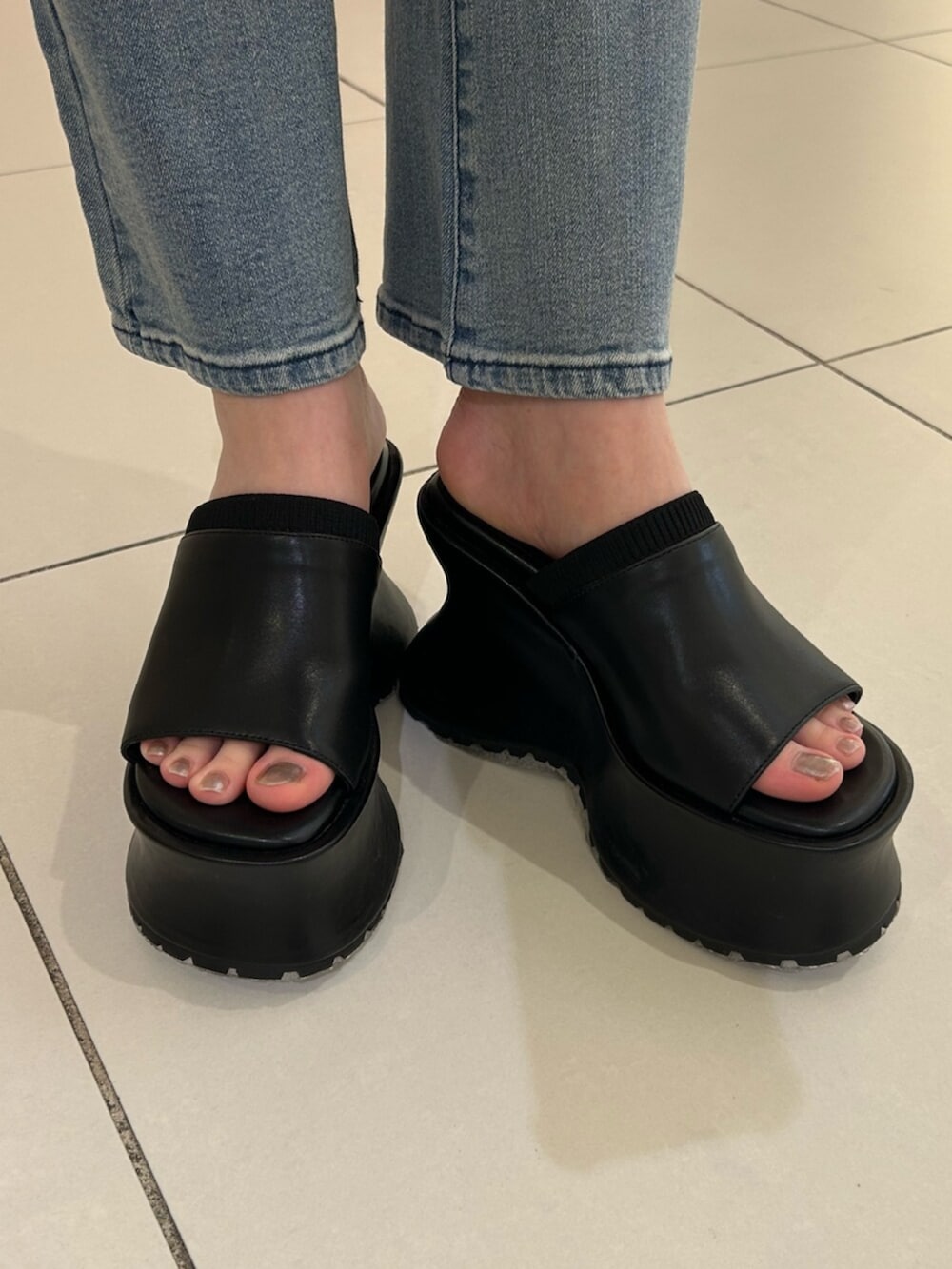 ブルー系のデニムパンツ、ブラック系のシャツ/ブラウス、ブラック系のサンダルを着用したレディースの夏コーディネートの4枚目の写真