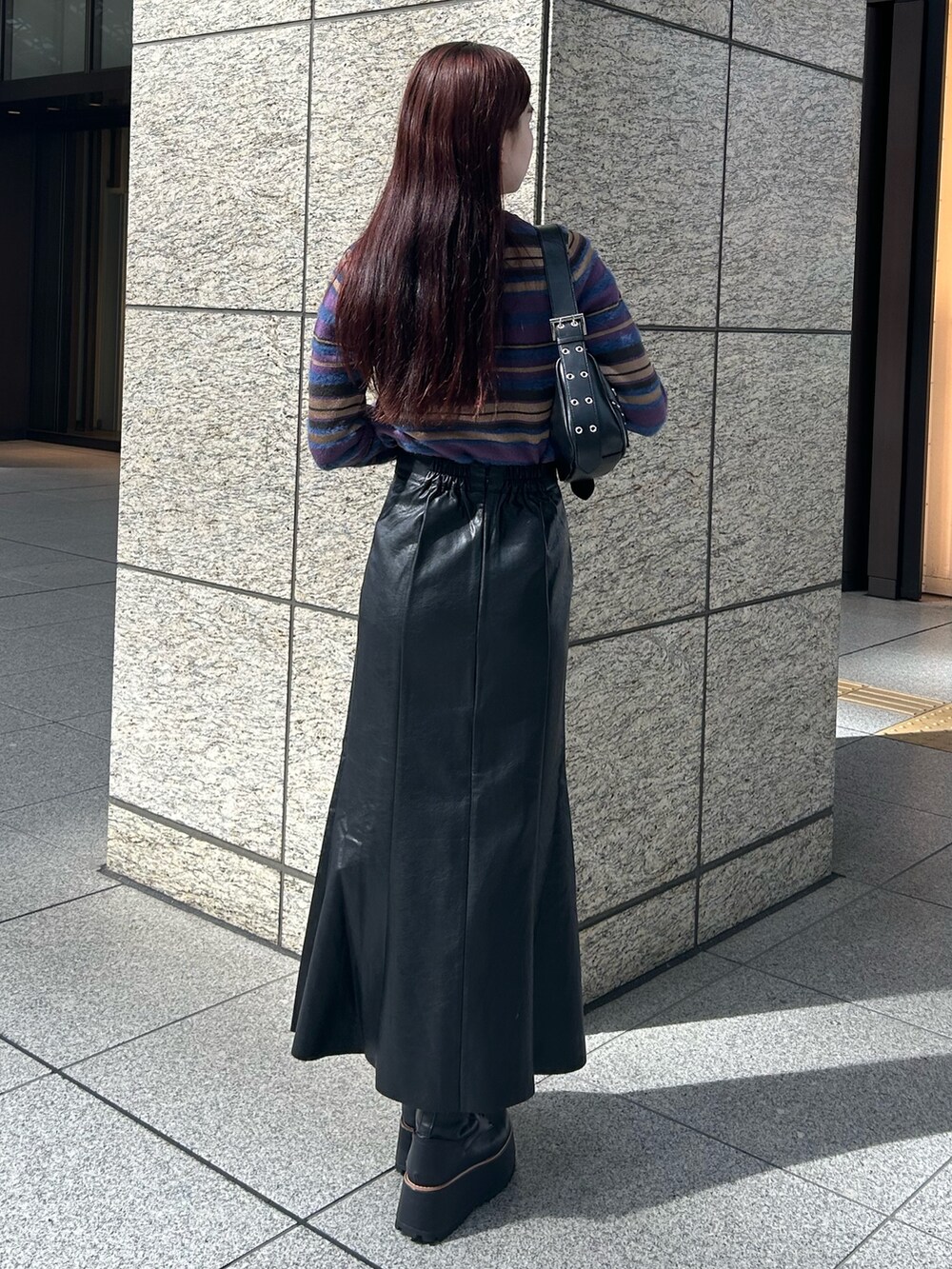 パープル系のニット/セーター、ブラック系のスカート、ブラック系のブーツを着用したレディースの秋コーディネートの3枚目の写真