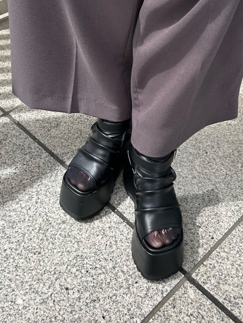 グレー系のベスト、グレー系のスラックス、ブラック系のTシャツ/カットソーを着用したレディースの春コーディネートの6枚目の写真