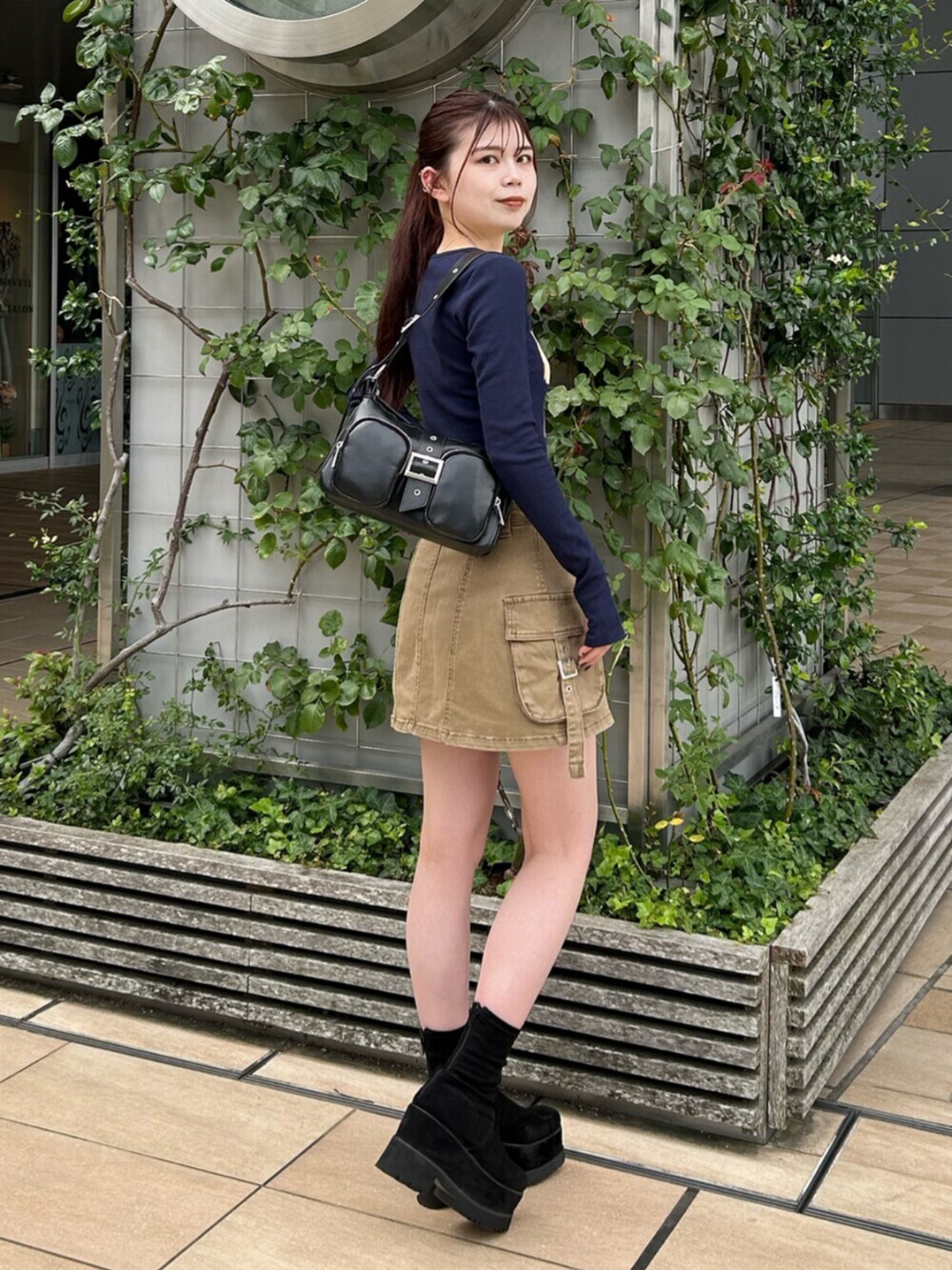 ブラック系のブーツ、ブルー系のTシャツ/カットソー、ベージュ系のスカートを着用したレディースの秋コーディネートの3枚目の写真