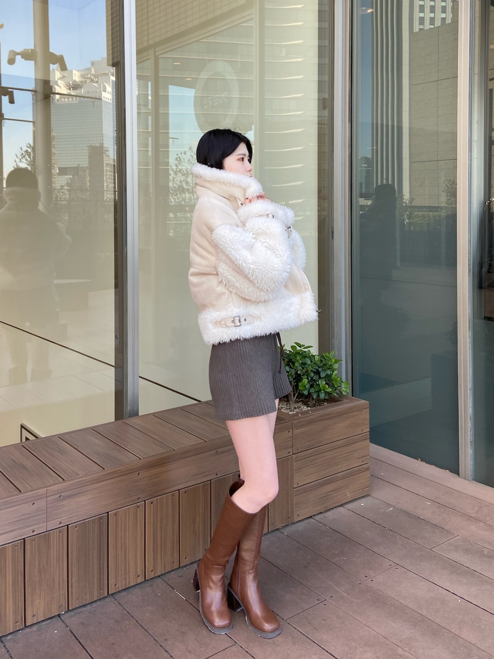 ホワイト系のムートンコート、その他のニット/セーター、グレー系のその他パンツを着用したレディースの冬コーディネートの2枚目の写真