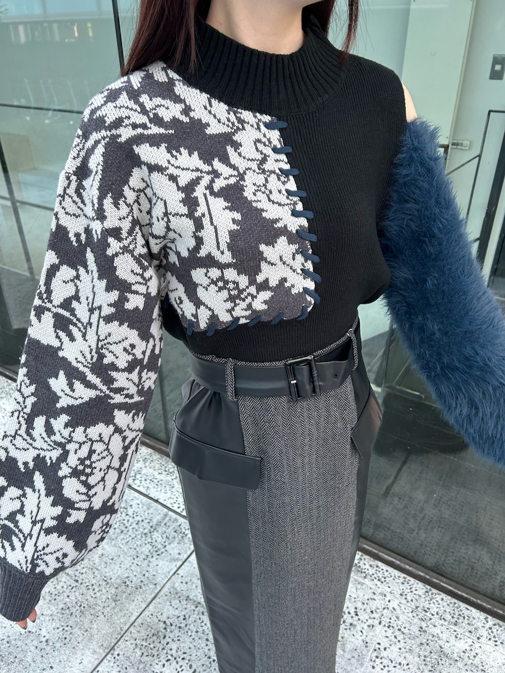 ブラック系のスカート、ブラック系のニット/セーター、ブラック系のブーツを着用したレディースの秋コーディネートの5枚目の写真
