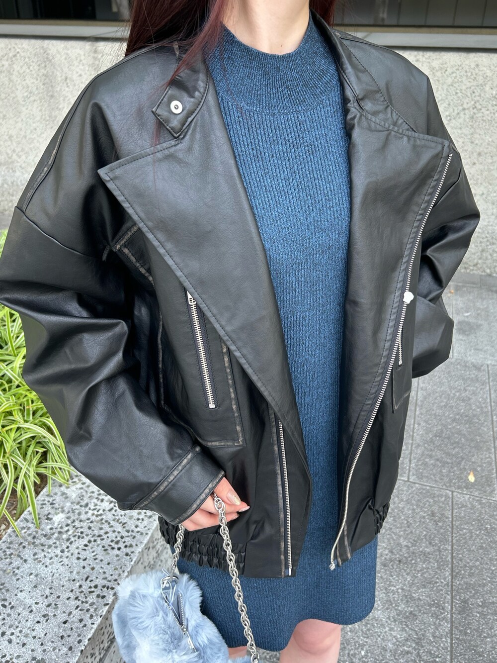 ブルー系のワンピース、ブラック系のライダースジャケット、ブラック系のブーツを着用したレディースの秋コーディネートの7枚目の写真