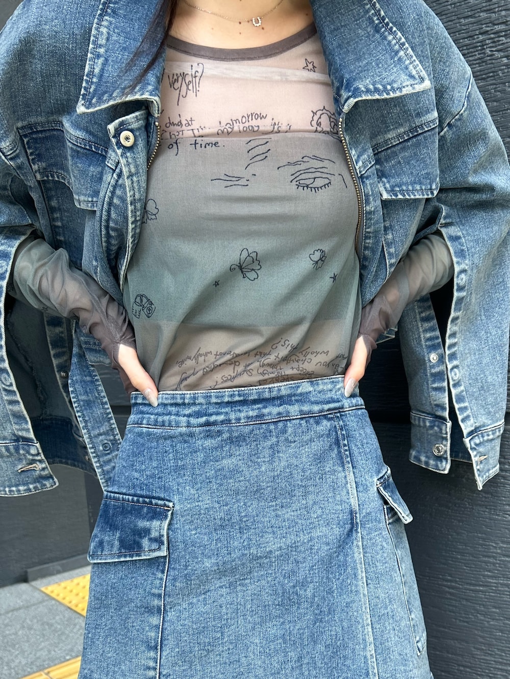 ブルー系のスカート、ブルー系のデニムジャケット、ブラック系のTシャツ/カットソーを着用したレディースの夏コーディネートの7枚目の写真