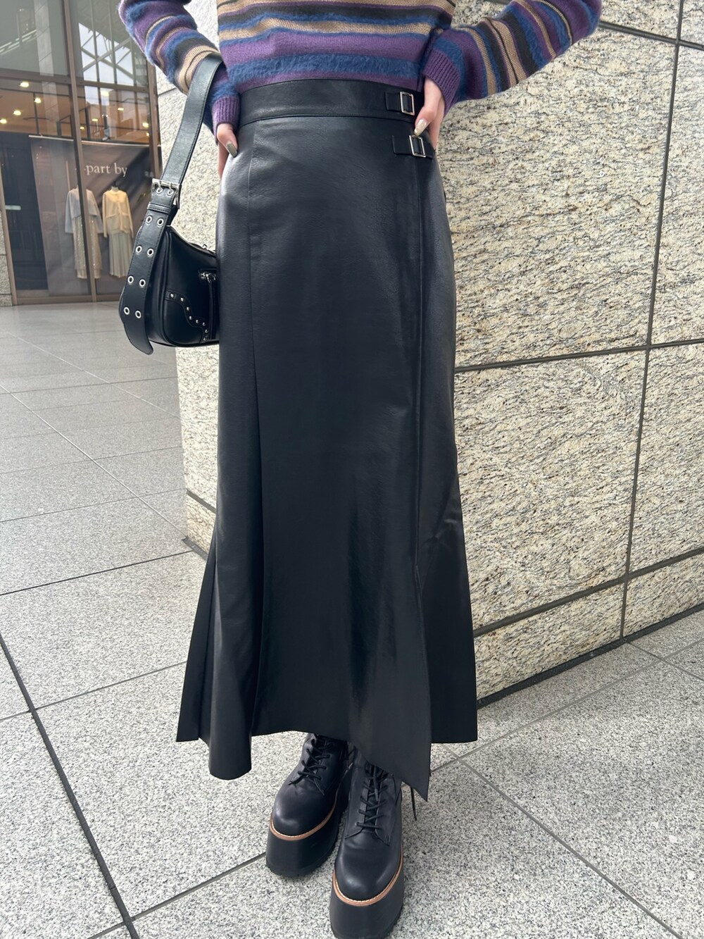 パープル系のニット/セーター、ブラック系のスカート、ブラック系のブーツを着用したレディースの秋コーディネートの6枚目の写真