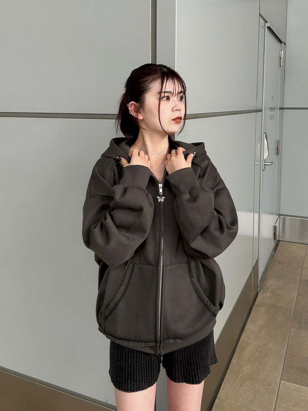 グレー系のパーカー、ブラック系のその他パンツ、ブラック系のブーツを着用したレディースの秋コーディネートの4枚目の写真