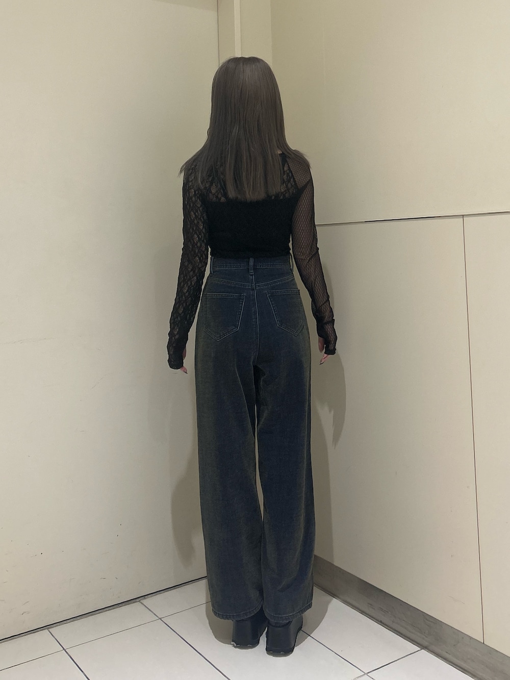グリーン系のデニムパンツ、ブラック系のTシャツ/カットソー、ブラック系のブーツを着用したレディースの秋コーディネートの3枚目の写真