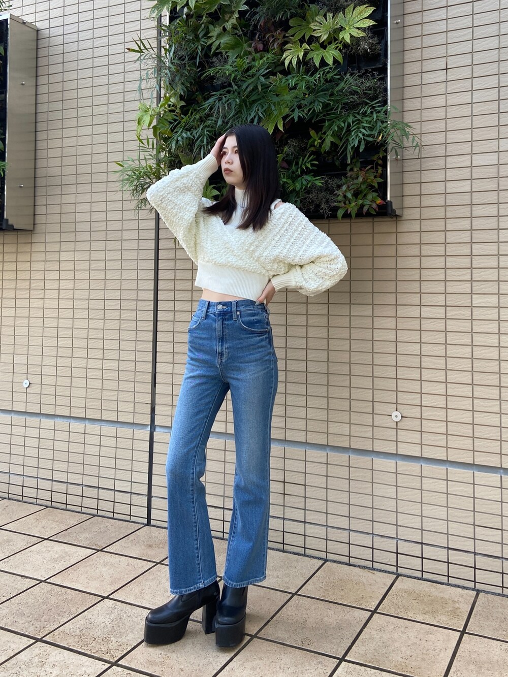 ブルー系のデニムパンツ、ホワイト系のニット/セーターを着用したレディースの秋コーディネートの2枚目の写真