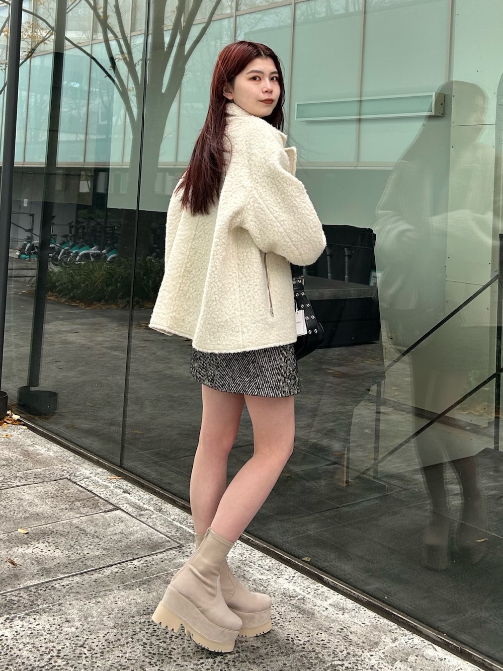 ホワイト系のブルゾン、ブルー系のニット/セーター、その他のスカートを着用したレディースの冬コーディネートの2枚目の写真