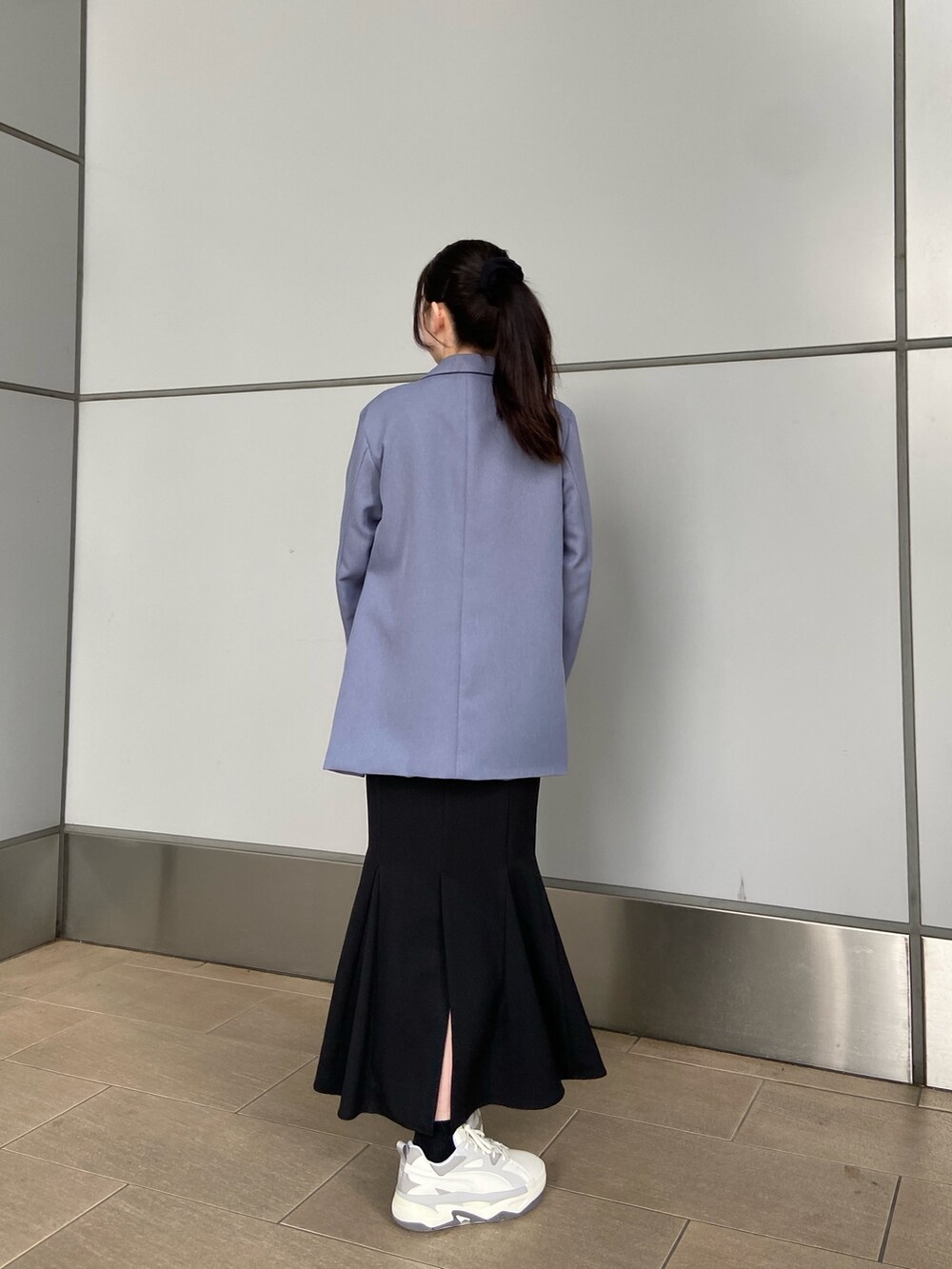 ブルー系のテーラードジャケット、ブラック系のTシャツ/カットソー、ブラック系のスカートを着用したレディースの冬コーディネートの2枚目の写真