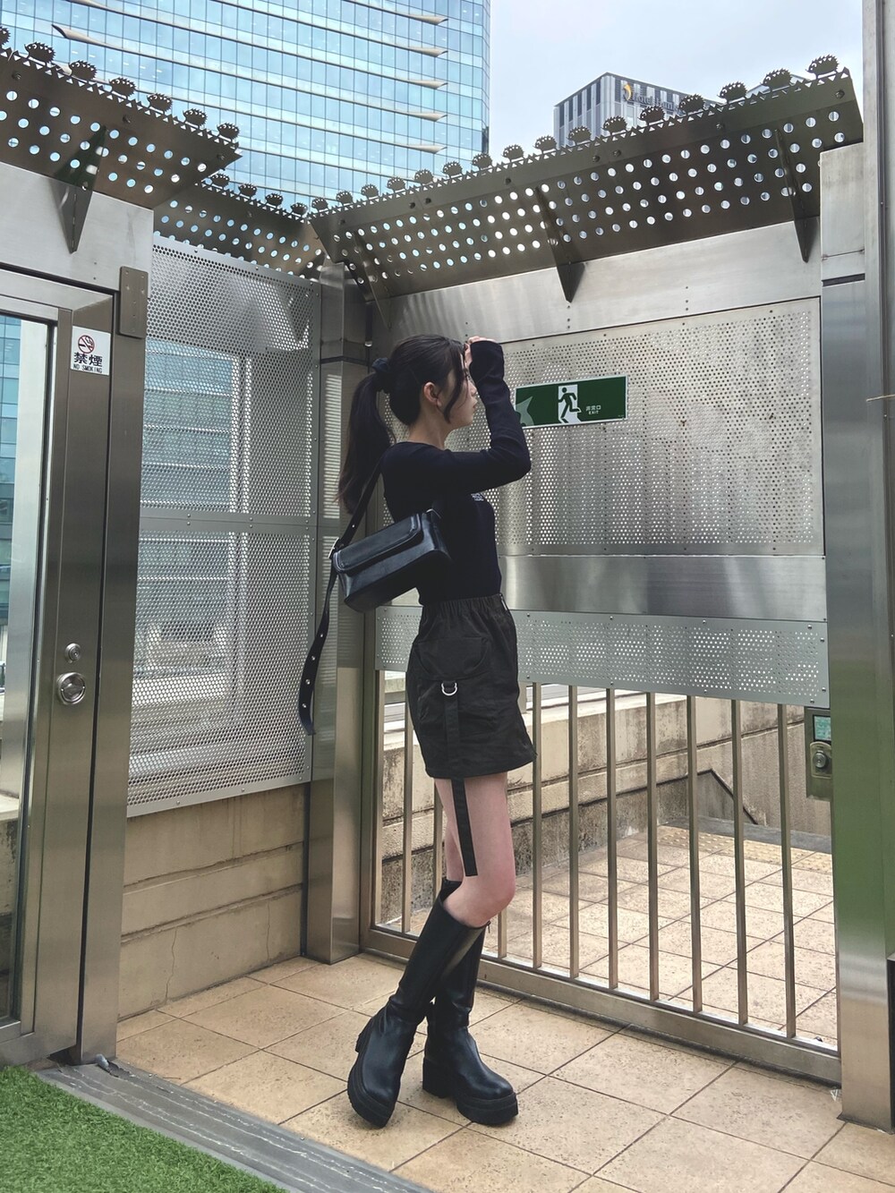 ベージュ系のスカート、ブラック系のTシャツ/カットソー、ブラック系のショルダーバッグを着用したレディースの冬コーディネートの2枚目の写真