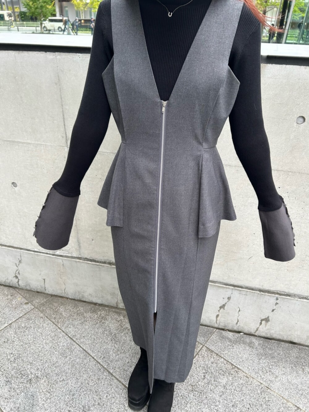 ブラック系のブーツ、グレー系のジャンパースカート、ブラック系のニット/セーターを着用したレディースの秋コーディネートの5枚目の写真