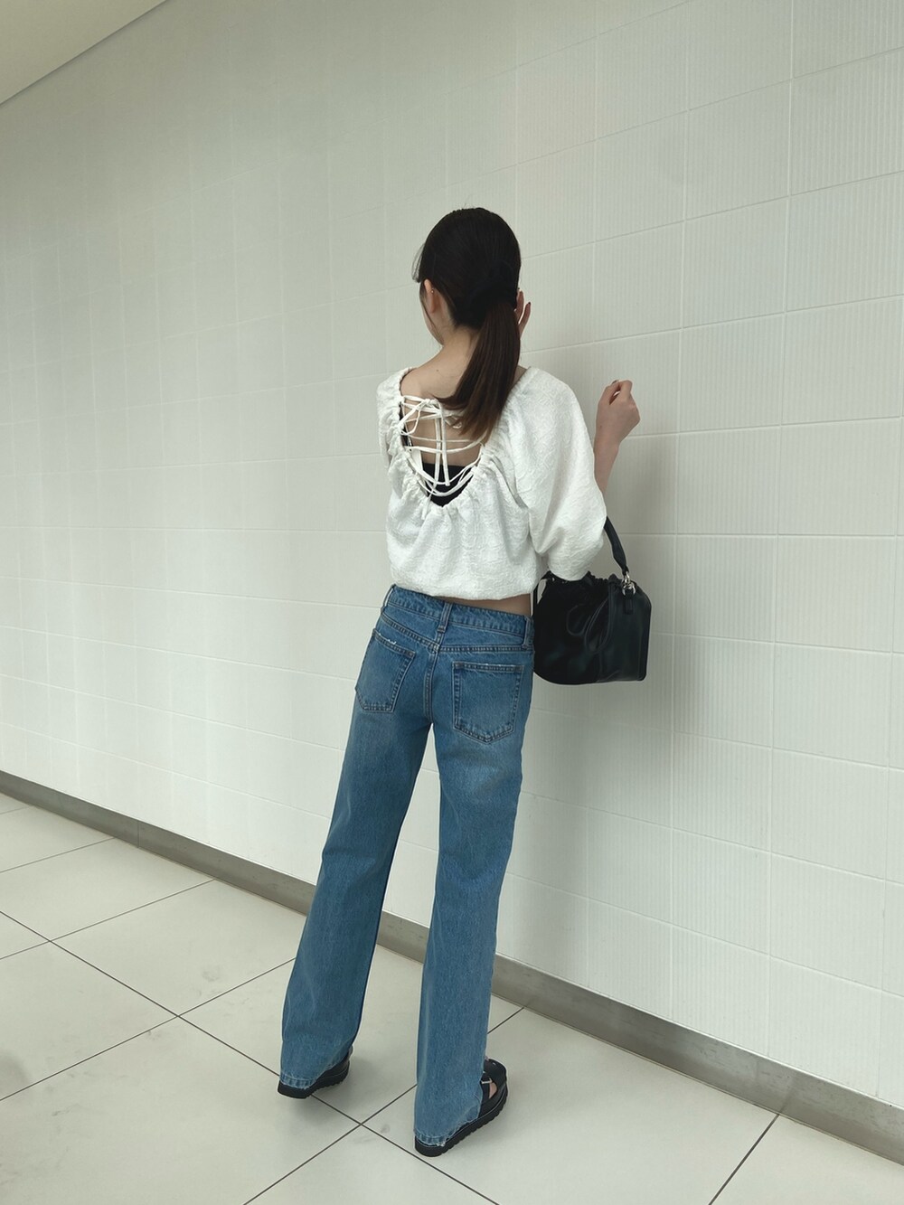 ホワイト系のシャツ/ブラウス、ブルー系のデニムパンツ、ブラック系のサンダルを着用したレディースの夏コーディネートの4枚目の写真