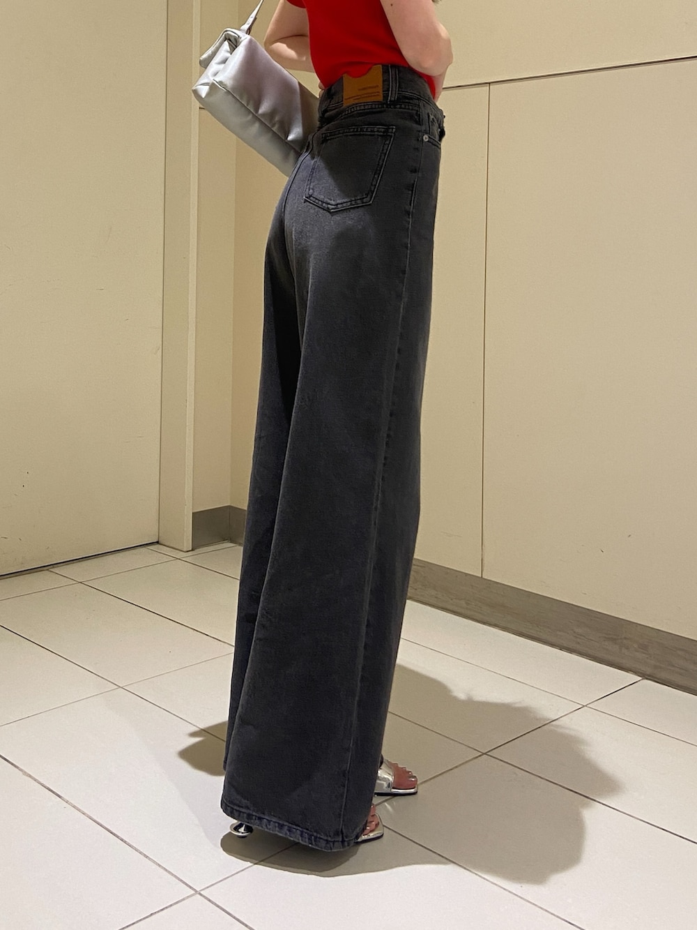 ブラック系のデニムパンツ、レッド系のニット/セーターを着用したレディースの夏コーディネートの6枚目の写真