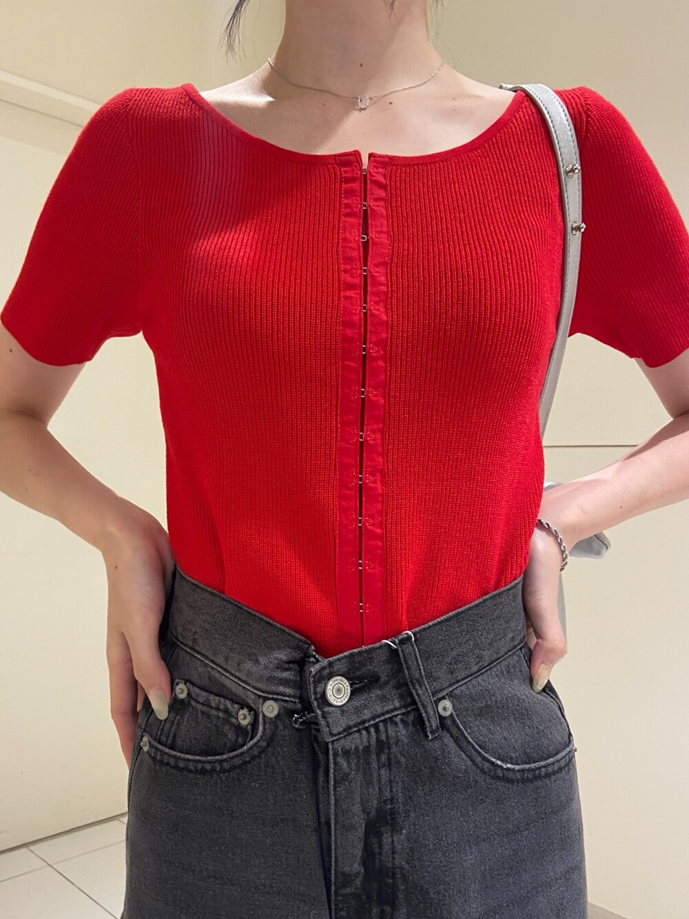 ブラック系のデニムパンツ、レッド系のニット/セーターを着用したレディースの夏コーディネートの4枚目の写真