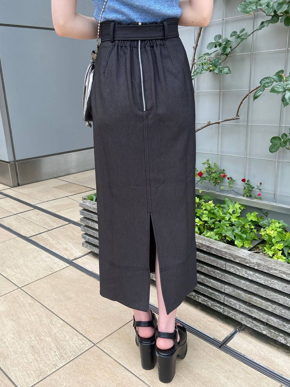 ブラック系のスカート、ブルー系のニット/セーターを着用したレディースの春コーディネートの7枚目の写真