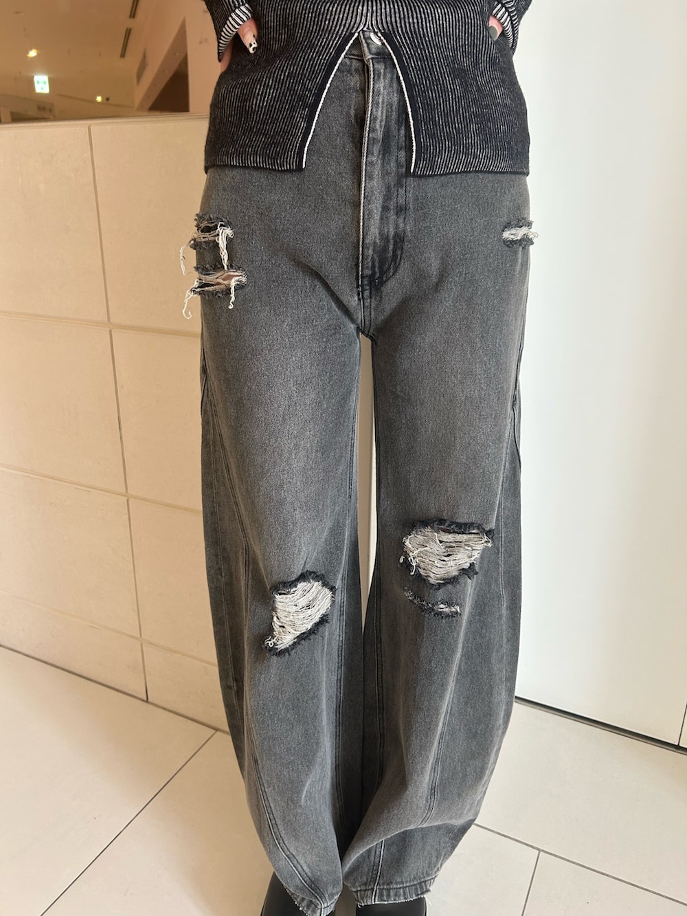 グレー系のデニムパンツ、その他のニット/セーター、ブラック系のブーツを着用したレディースの秋コーディネートの6枚目の写真