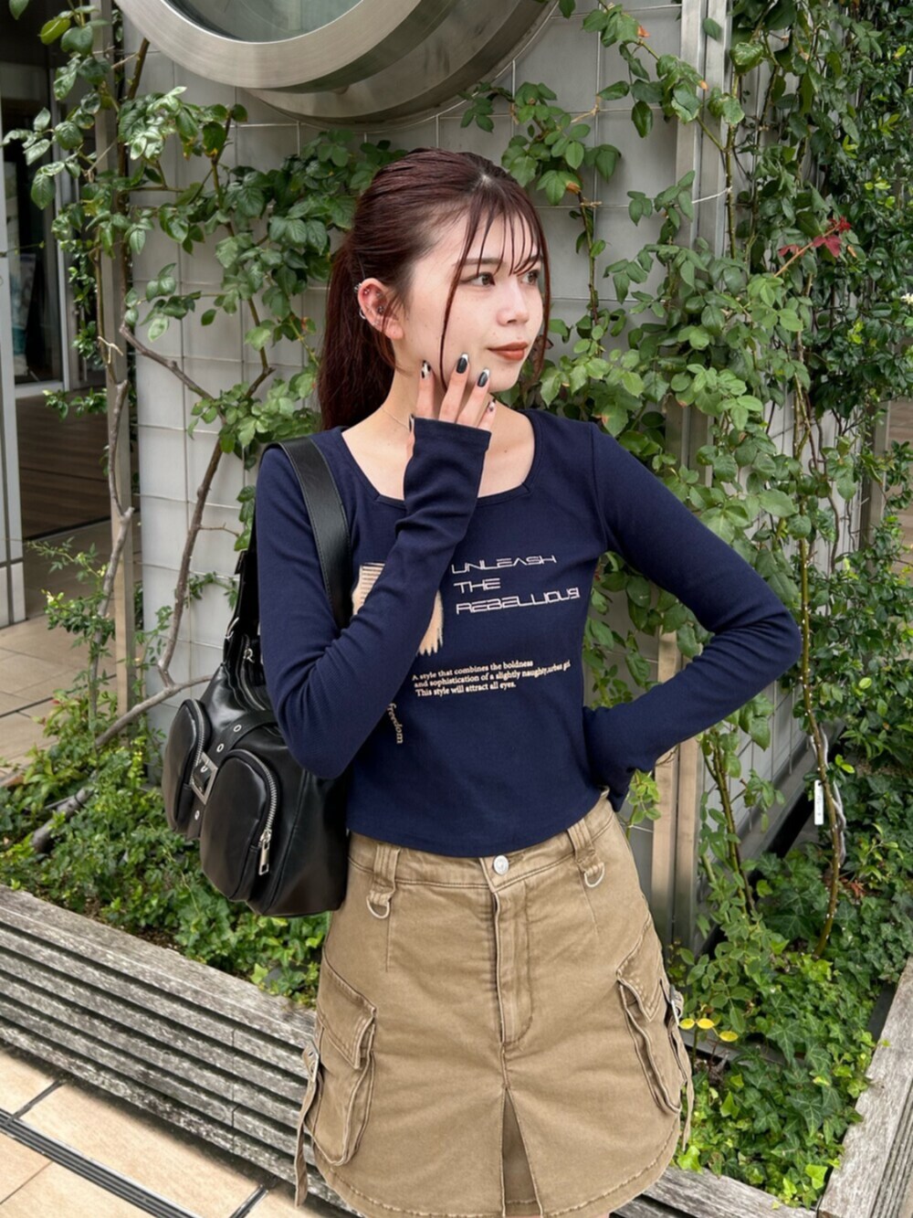 ブラック系のブーツ、ブルー系のTシャツ/カットソー、ベージュ系のスカートを着用したレディースの秋コーディネートの4枚目の写真