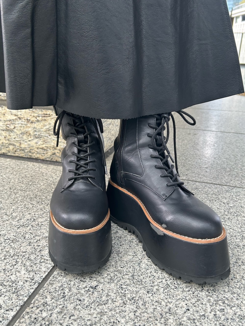 パープル系のニット/セーター、ブラック系のスカート、ブラック系のブーツを着用したレディースの秋コーディネートの7枚目の写真