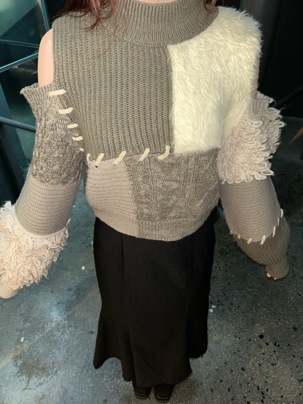 ブラウン系のニット/セーター、ブラック系のスカート、ブラック系のブーツを着用したレディースの冬コーディネートの5枚目の写真