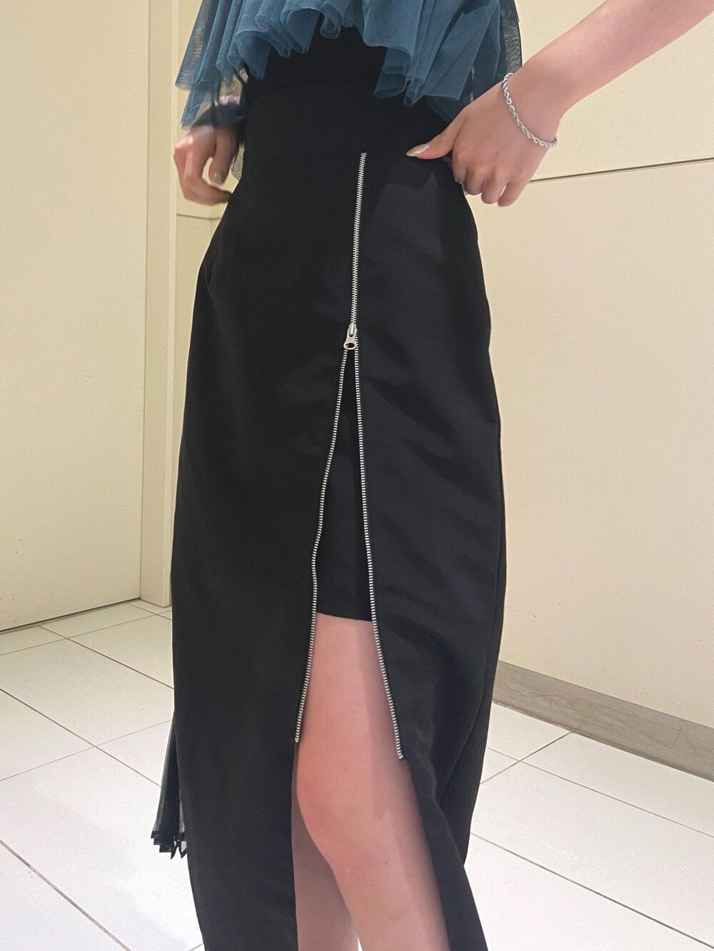 ブラック系のスカート、ブラック系のTシャツ/カットソー、シルバー系のサンダルを着用したレディースの夏コーディネートの6枚目の写真