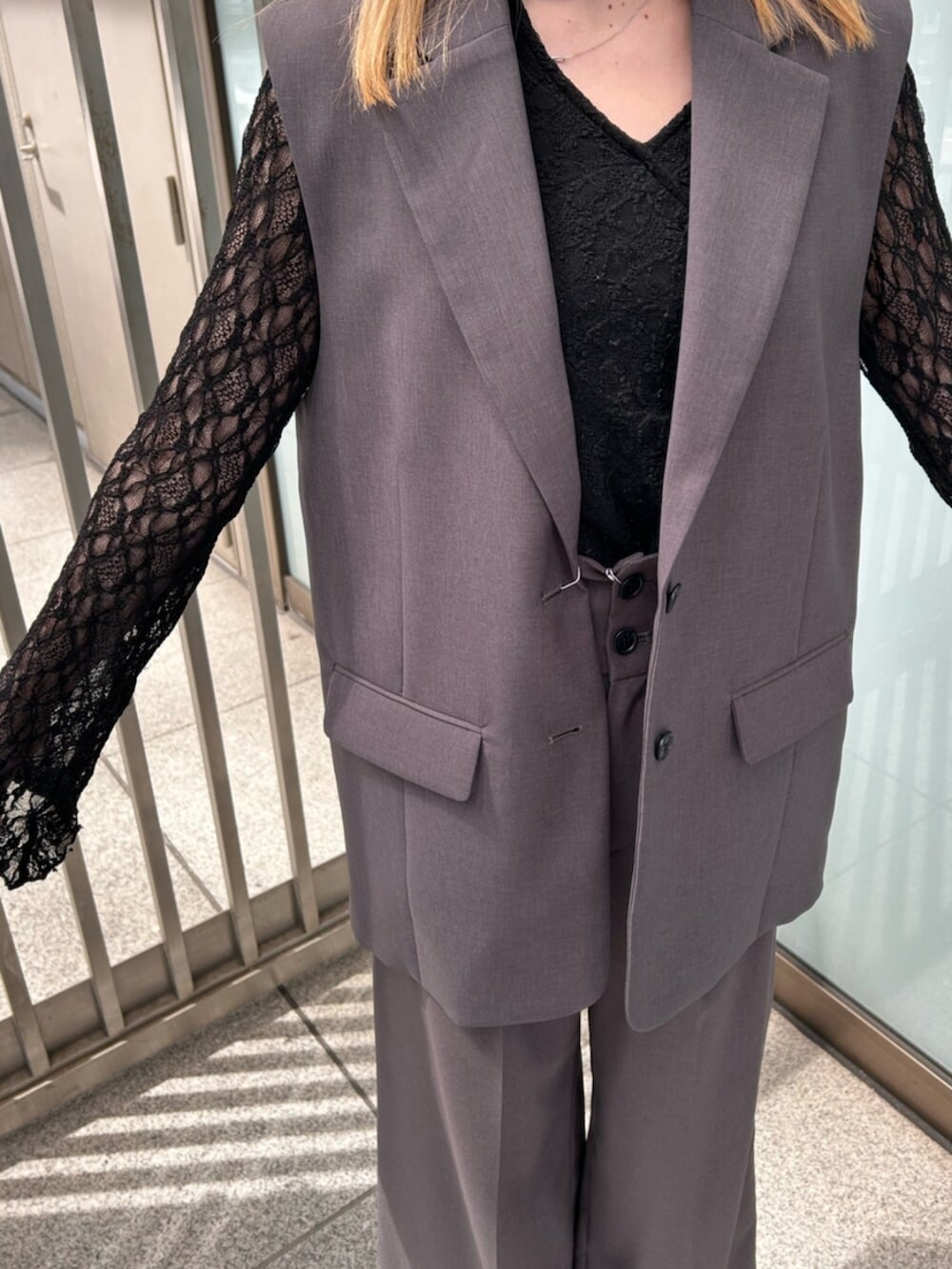 グレー系のベスト、グレー系のスラックス、ブラック系のTシャツ/カットソーを着用したレディースの春コーディネートの4枚目の写真