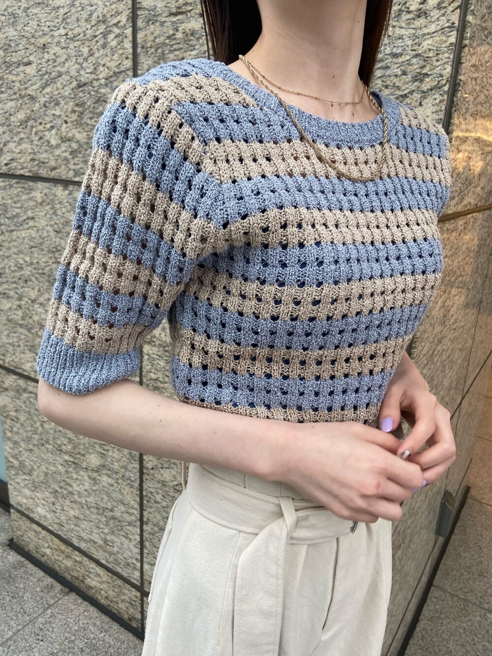 ブルー系のニット/セーター、ホワイト系のデニムパンツ、ブラック系のサンダルを着用したレディースの春コーディネートの4枚目の写真