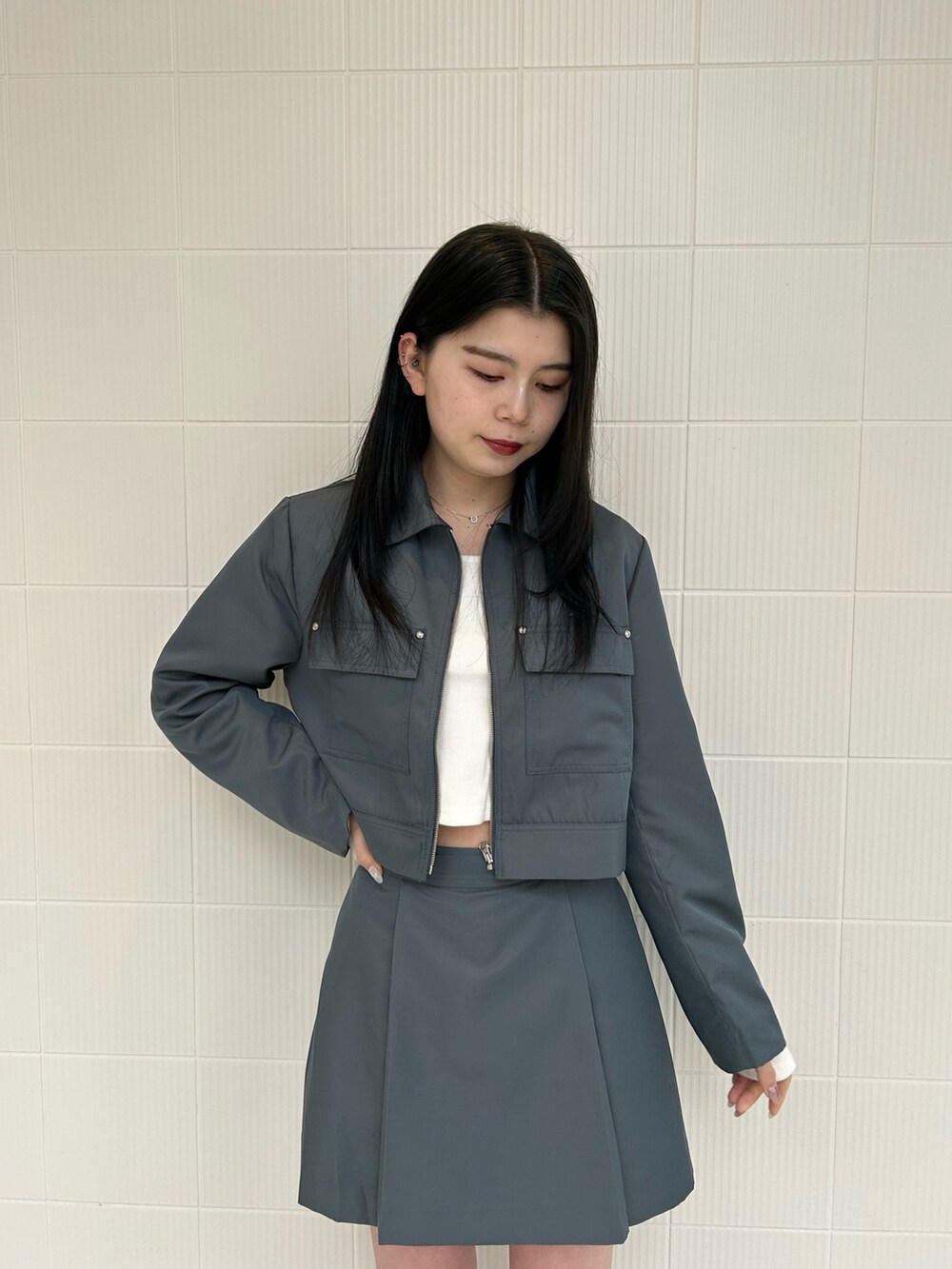 グレー系のスカート、グレー系のブルゾン、ホワイト系のTシャツ/カットソーを着用したレディースの春コーディネートの4枚目の写真