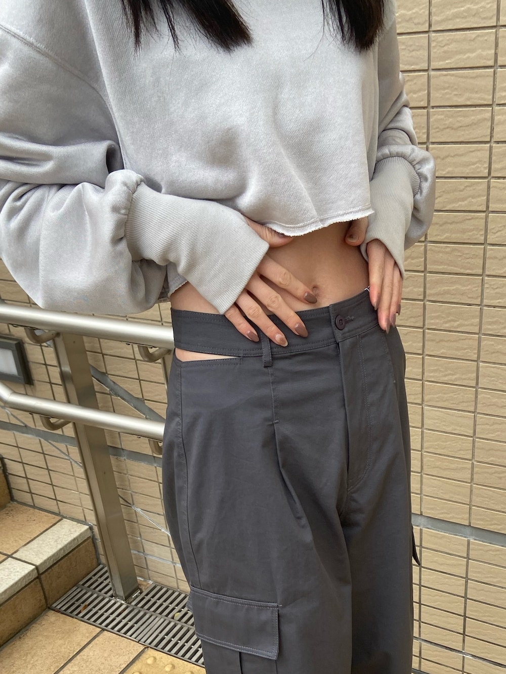 グレー系のカーゴパンツ、グレー系のTシャツ/カットソー、グリーン系のキャップを着用したレディースの冬コーディネートの6枚目の写真