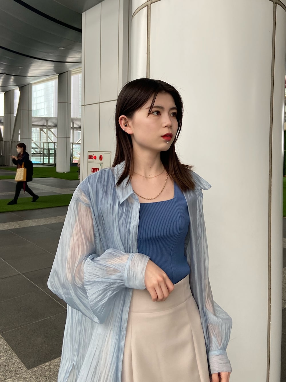 ブルー系のシャツ/ブラウス、ベージュ系のスカート、ブルー系のタンクトップを着用したレディースの春コーディネートの3枚目の写真