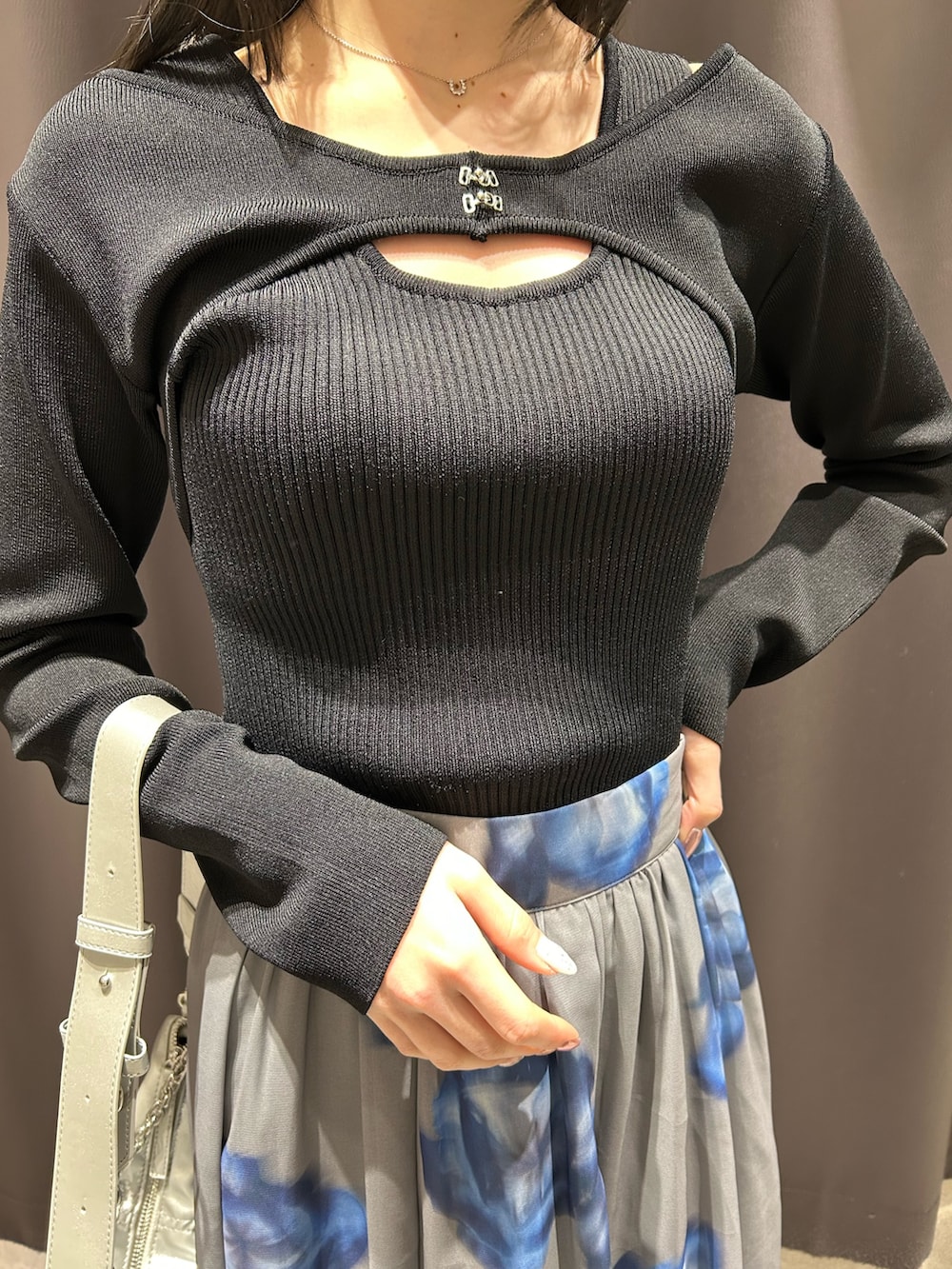 ブラック系のニット/セーター、グレー系のスカート、ホワイト系のブーツを着用したレディースの春コーディネートの4枚目の写真