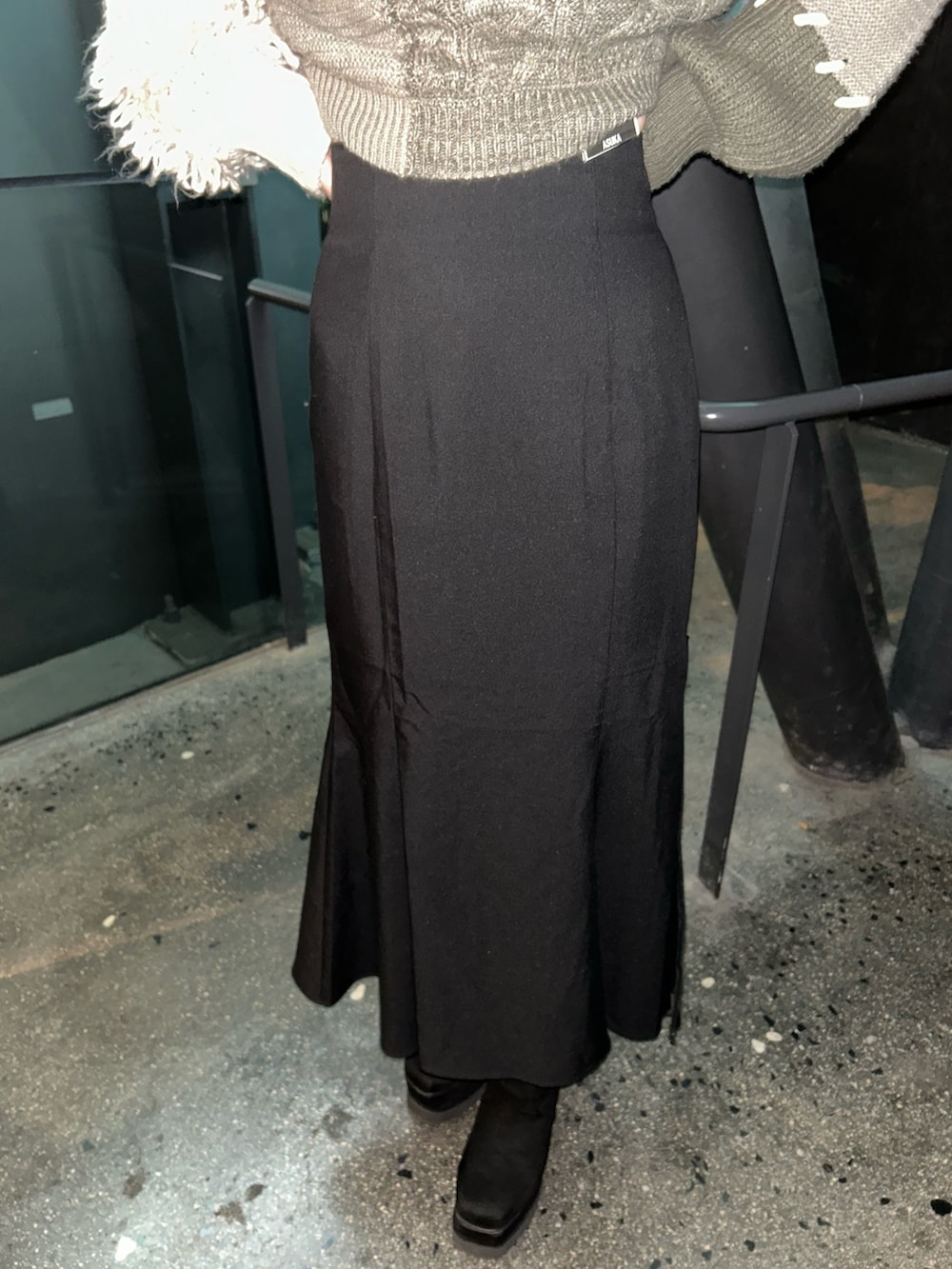 ブラウン系のニット/セーター、ブラック系のスカート、ブラック系のブーツを着用したレディースの冬コーディネートの6枚目の写真