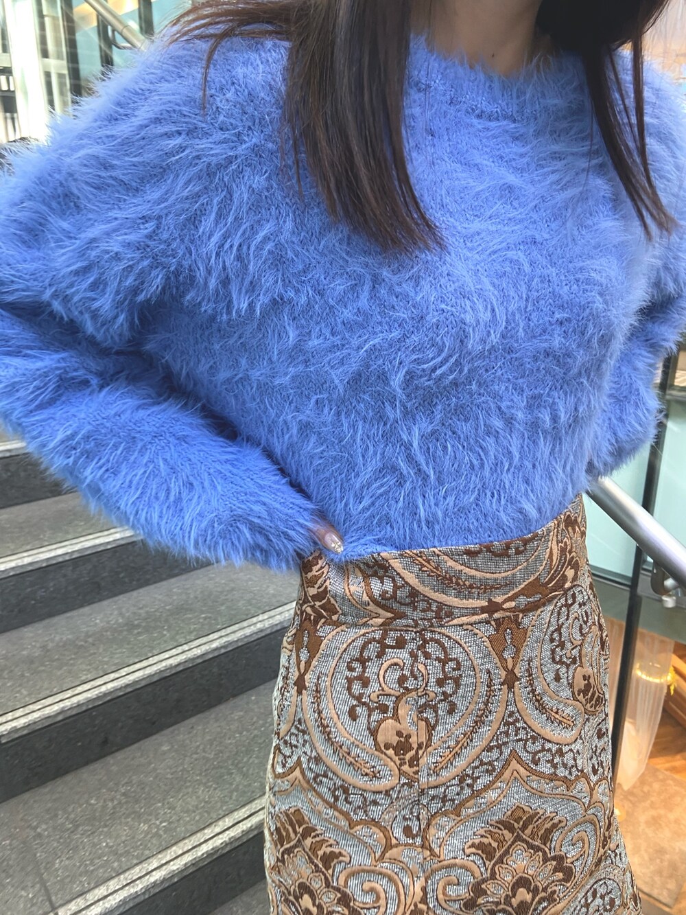 ブルー系のスカート、ブルー系のニット/セーター、ホワイト系のブーツを着用したレディースの秋コーディネートの5枚目の写真