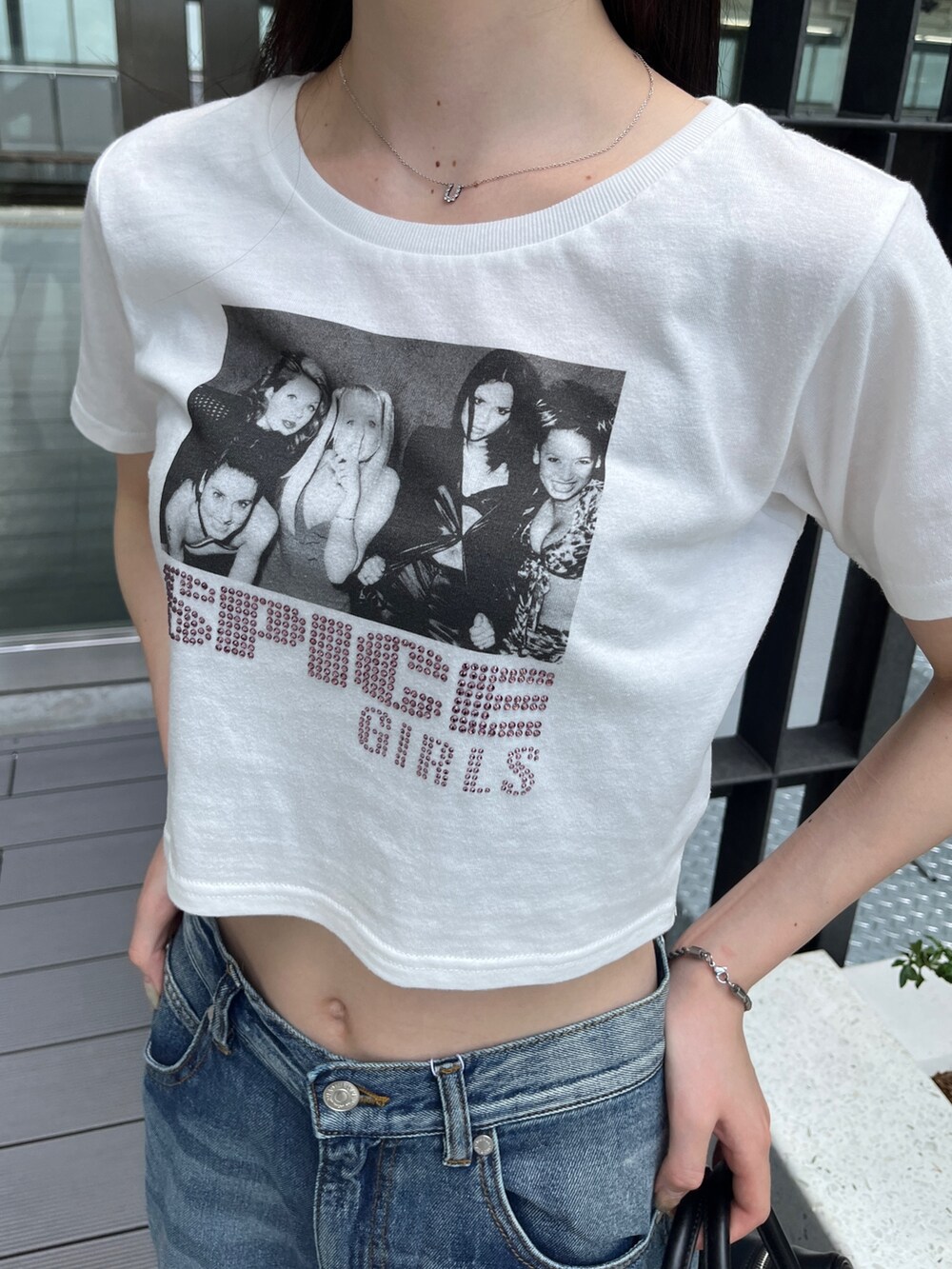 ブルー系のデニムパンツ、ホワイト系のTシャツ/カットソー、ブラック系のボストンバッグを着用したレディースの夏コーディネートの5枚目の写真