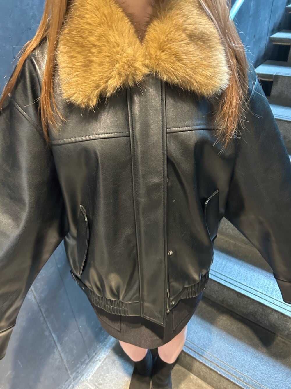 ブラック系のブーツ、ブラック系のブルゾン、ブラック系のスカートを着用したレディースの春コーディネートの6枚目の写真