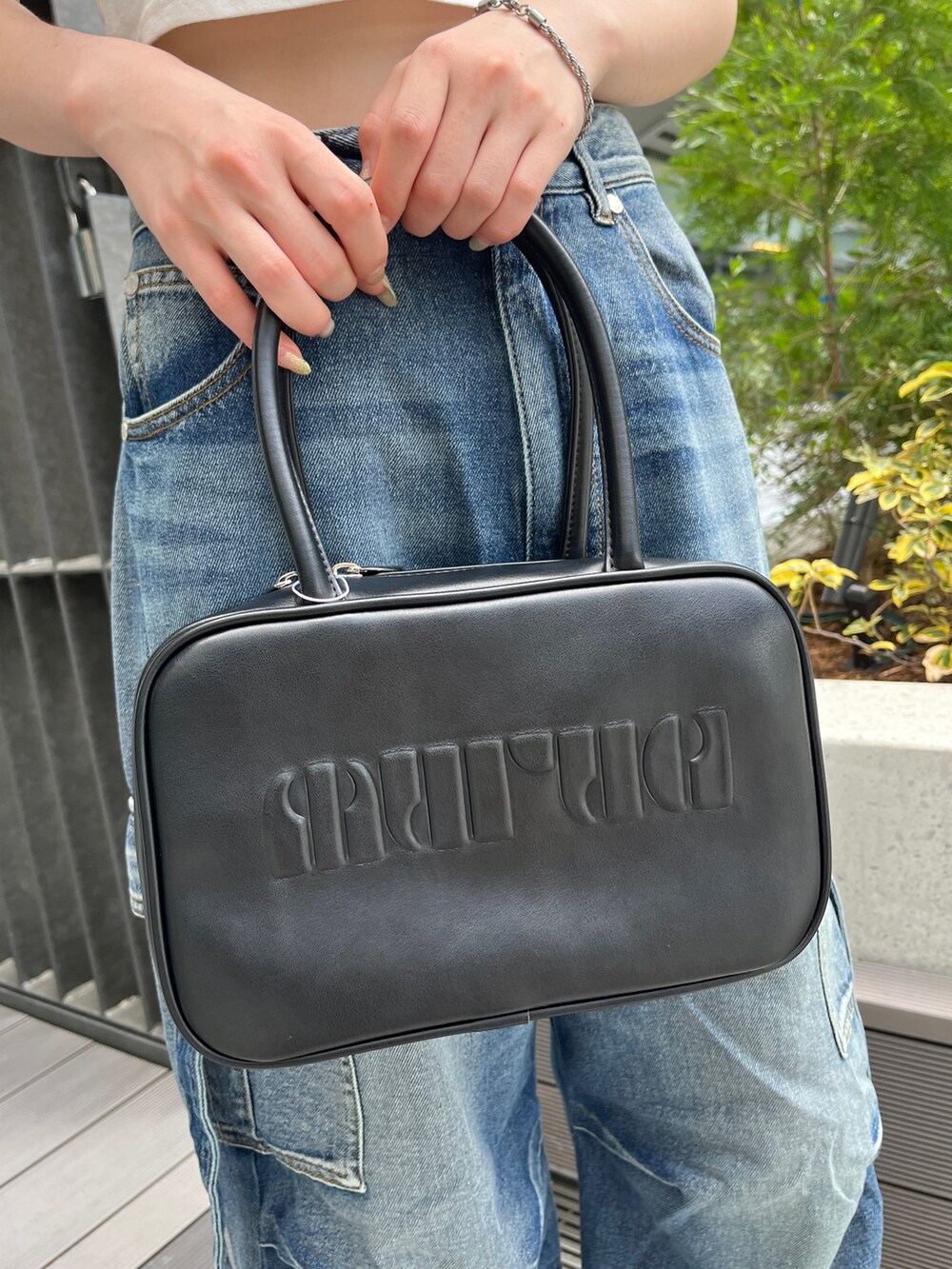 ブルー系のデニムパンツ、ホワイト系のTシャツ/カットソー、ブラック系のボストンバッグを着用したレディースの夏コーディネートの10枚目の写真