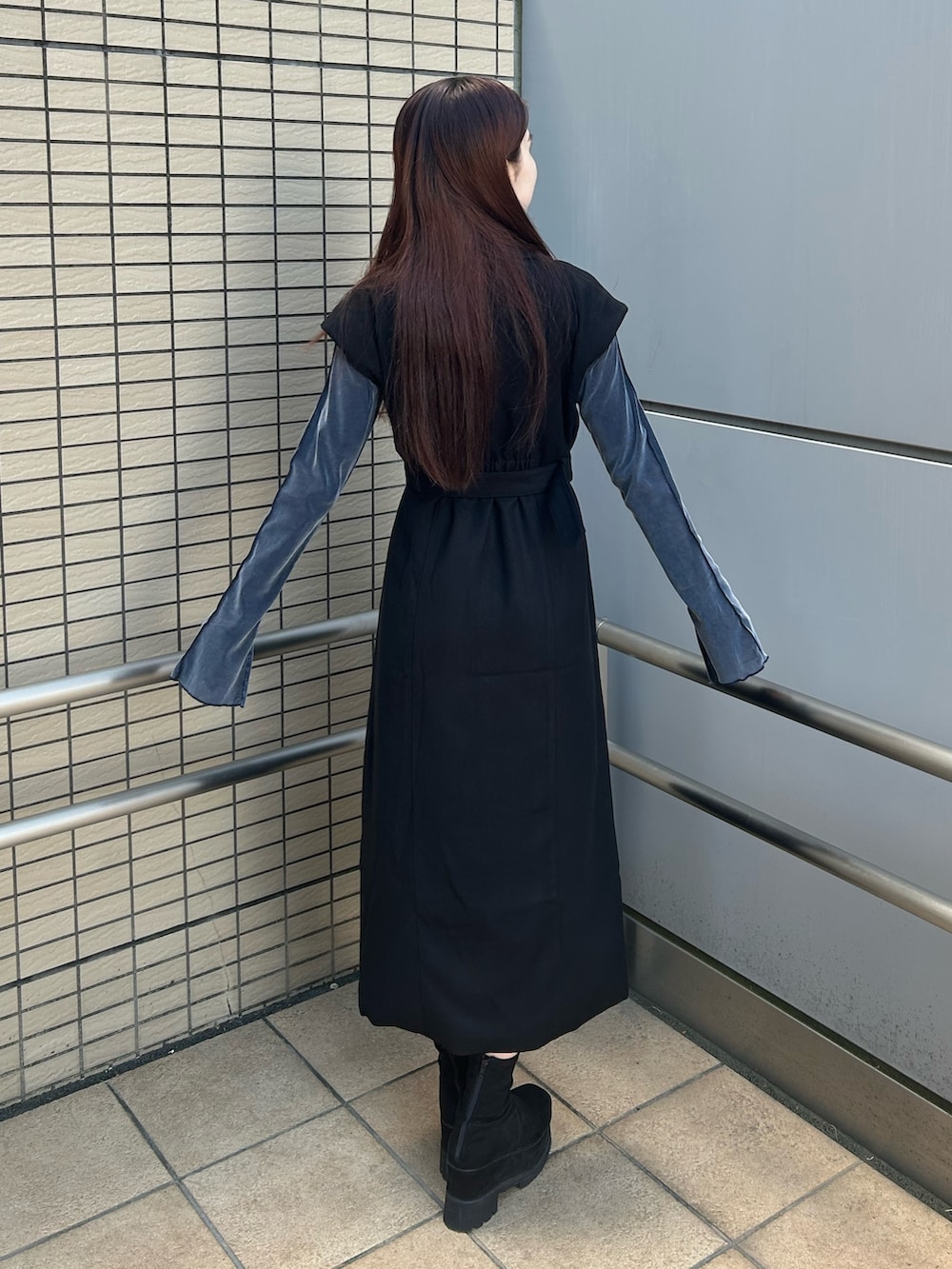 ブラック系のワンピース、ブラック系のブーツを着用したレディースの秋コーディネートの2枚目の写真