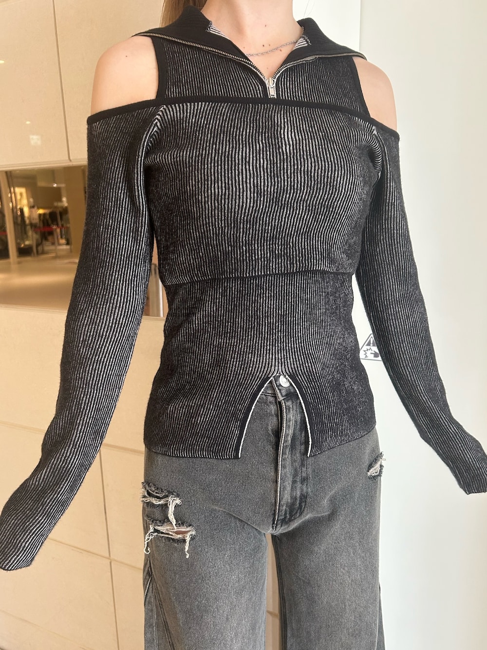 グレー系のデニムパンツ、その他のニット/セーター、ブラック系のブーツを着用したレディースの秋コーディネートの5枚目の写真