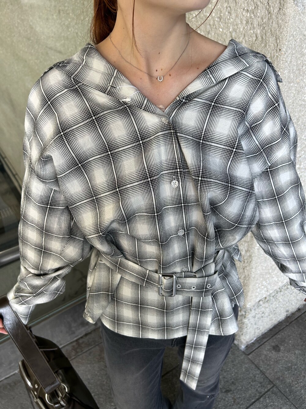 ホワイト系のシャツ/ブラウス、ブラック系のデニムパンツ、ブラック系のブーツを着用したレディースの秋コーディネートの5枚目の写真