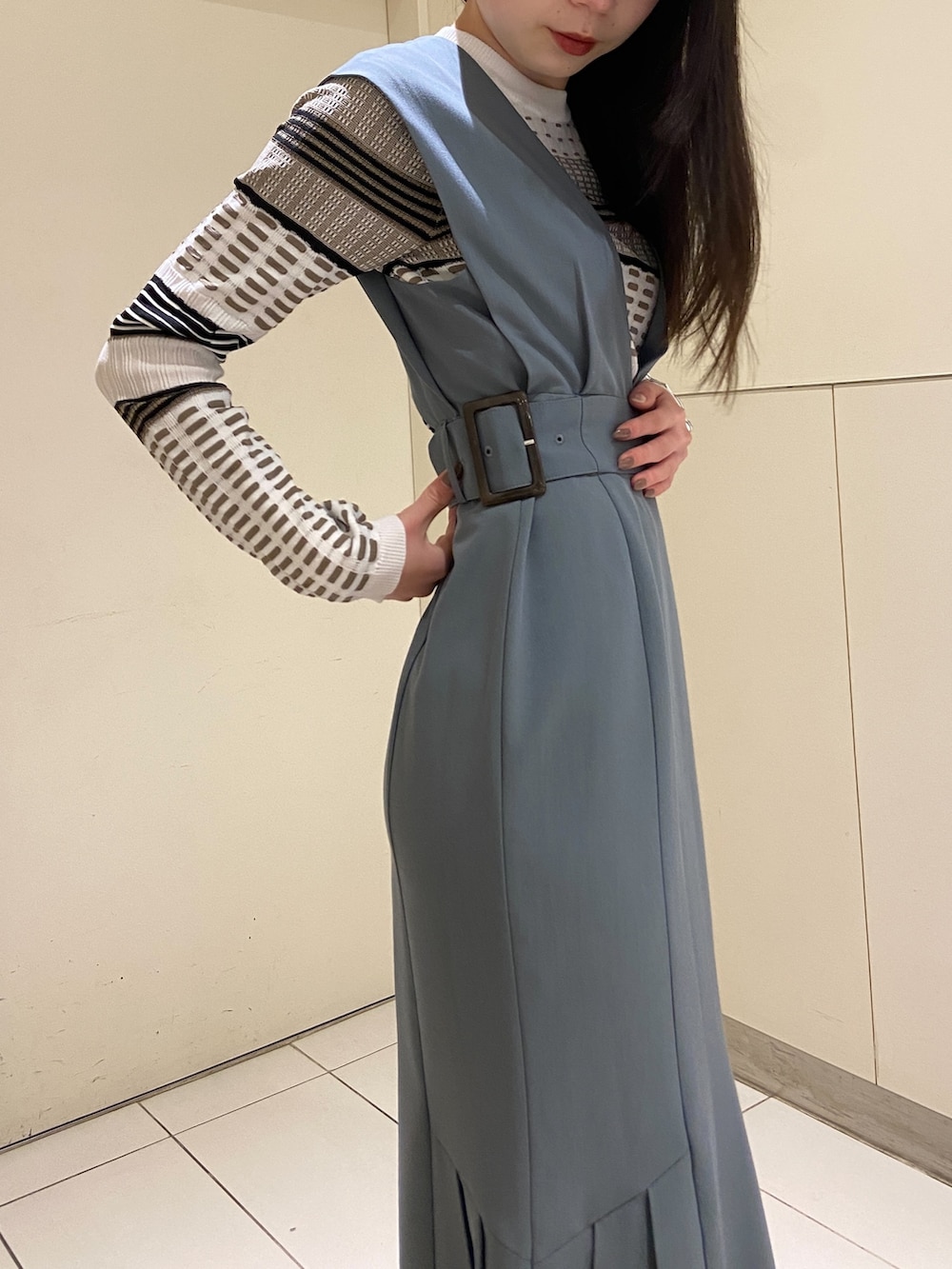 ブルー系のワンピース、ホワイト系のニット/セーター、ブラック系のブーツを着用したレディースの冬コーディネートの5枚目の写真