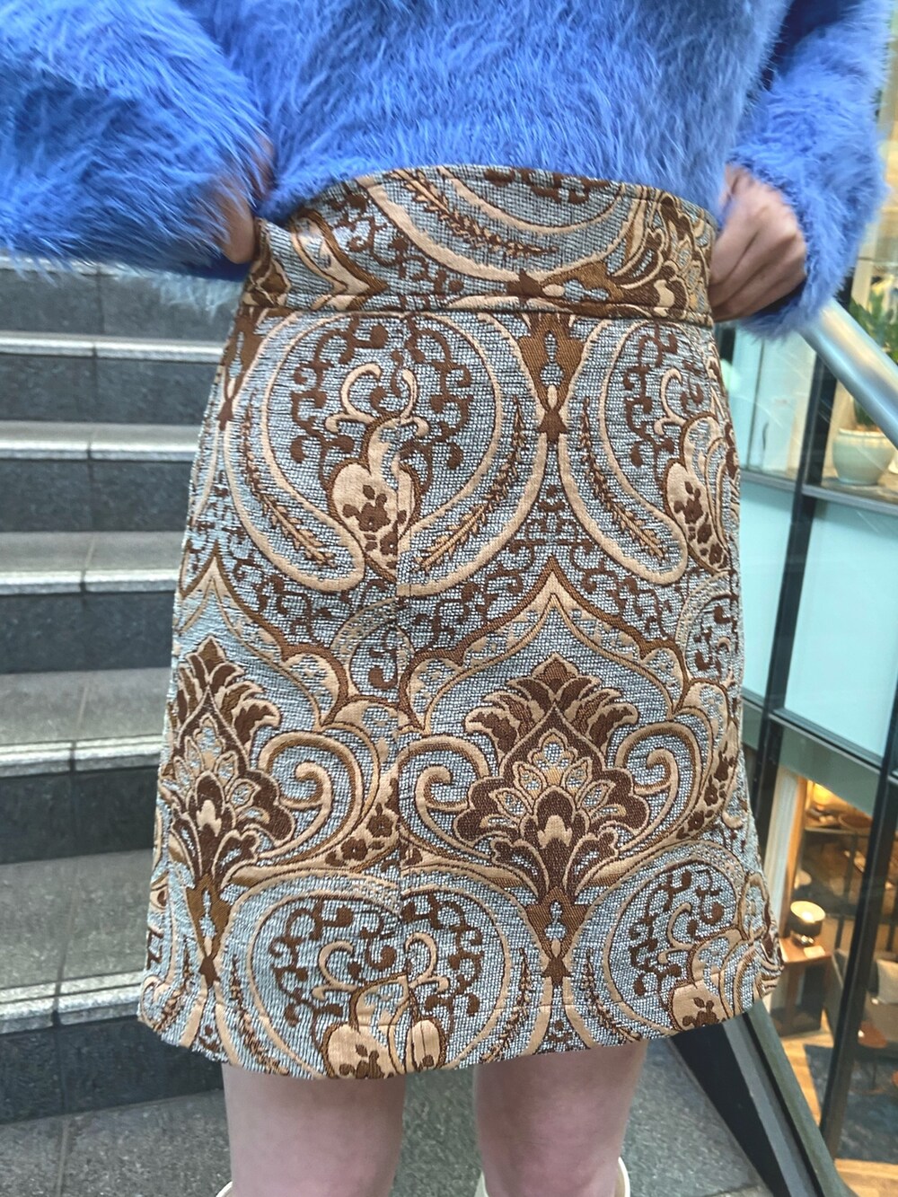 ブルー系のスカート、ブルー系のニット/セーター、ホワイト系のブーツを着用したレディースの秋コーディネートの6枚目の写真