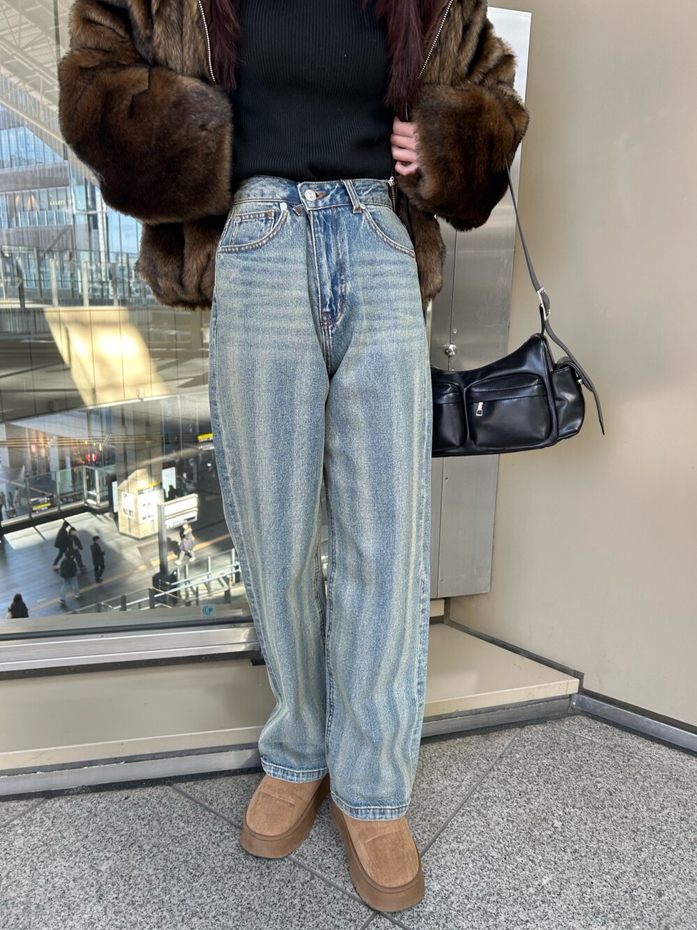 ブルー系のデニムパンツ、ブラウン系のブルゾン、ブラック系のニット/セーターを着用したレディースの冬コーディネートの8枚目の写真