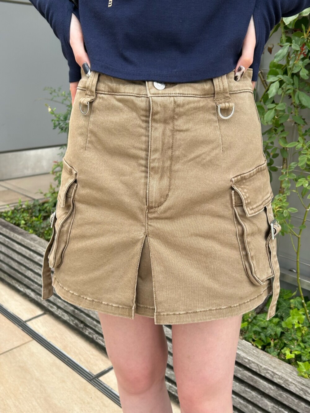 ブラック系のブーツ、ブルー系のTシャツ/カットソー、ベージュ系のスカートを着用したレディースの秋コーディネートの6枚目の写真