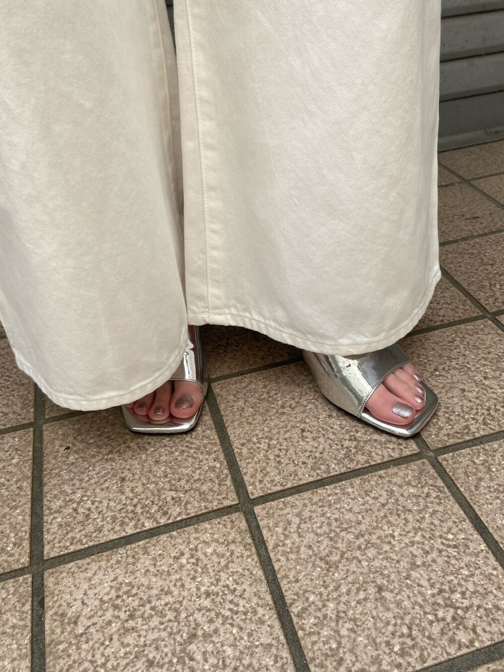 ホワイト系のデニムパンツ、ホワイト系のTシャツ/カットソー、シルバー系のサンダルを着用したレディースの春コーディネートの9枚目の写真
