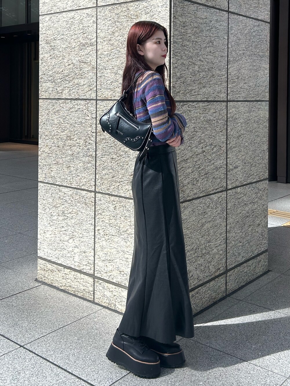 パープル系のニット/セーター、ブラック系のスカート、ブラック系のブーツを着用したレディースの秋コーディネートの2枚目の写真